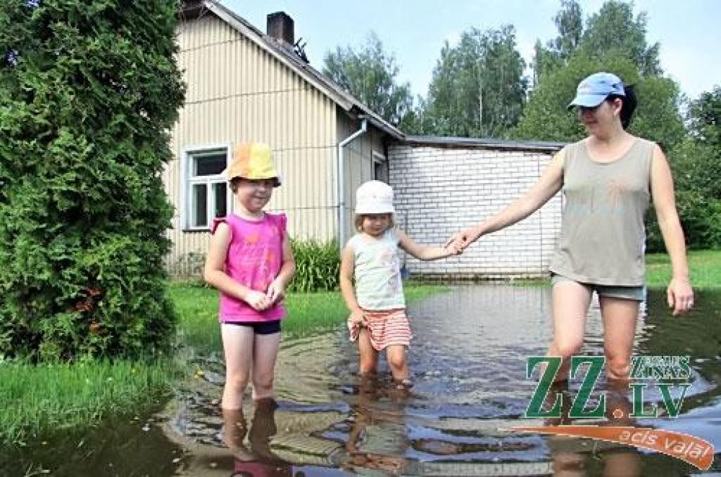 FOTO: Negaiss lauž kokus un slīcina dārzus